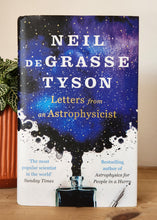 Load image into Gallery viewer, Book titled 'Letters from an Astrophysicist' by Neil deGrasse Tyson on a wooden surface.