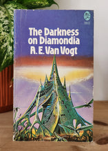 Load image into Gallery viewer, Book titled 'The Darkness on Diamondia' by A.E. Van Vogt on a wooden surface with a plant in the background