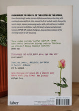 Load image into Gallery viewer, Book back cover with a rose illustration on a wooden surface